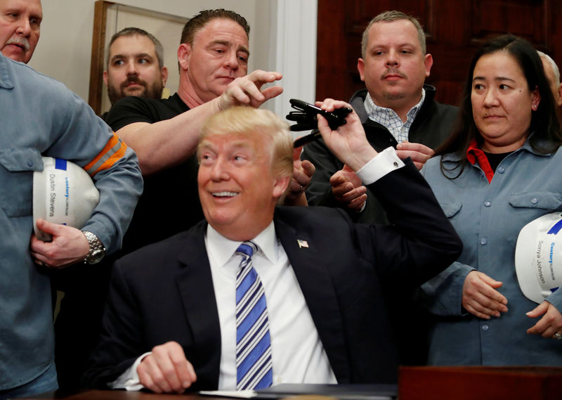 © Reuters. U.S. President Donald Trump signs a presidential proclamation placing tariffs on steel and aluminum imports while surrounded by workers from the steel and aluminum industries at the White House in Washington