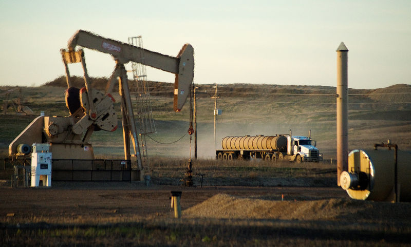 © Reuters. FILE PHOTO: A service truck drives past an oil well on the Fort Berthold Indian Reservation in North Dakota