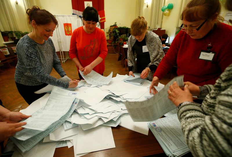 © Reuters. Members of a local election commission sort ballots before starting to count votes during the presidential election at a polling station in a settlement in Smolensk Region
