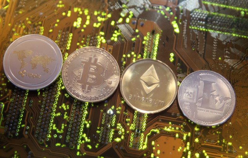 © Reuters. Representations of the Ripple, Bitcoin, Etherum and Litecoin virtual currencies are seen on motherboard in this illustration picture