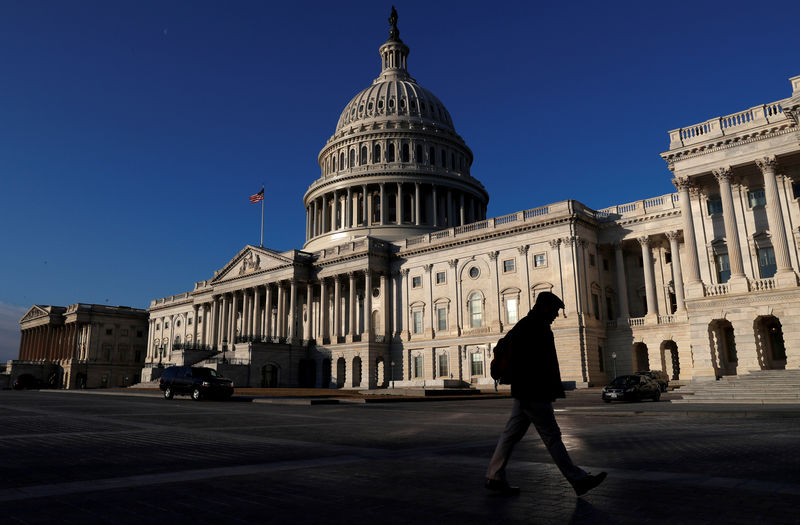 © Reuters. FILE PHOTO - People walk by the U.S. Capitol building in Washington