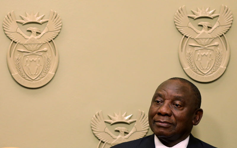 © Reuters. President Cyril Ramaphosa watches as his new cabinet ministers are sworn in Cape Town