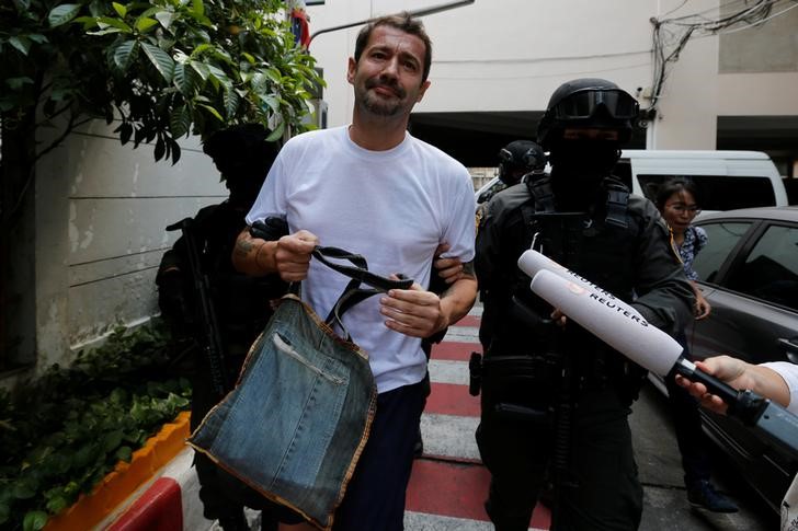 © Reuters. FILE PHOTO - Swiss national Justo is escorted by Thai police commandos as he arrives at the Immigration Detention Center in Bangkok