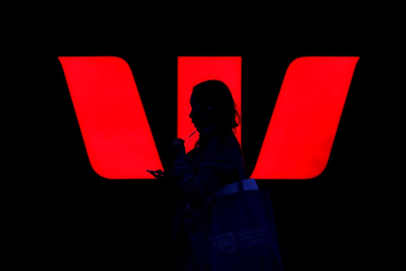 © Reuters. A woman walks past an illuminated logo for Australia's Westpac Bank in Sydney