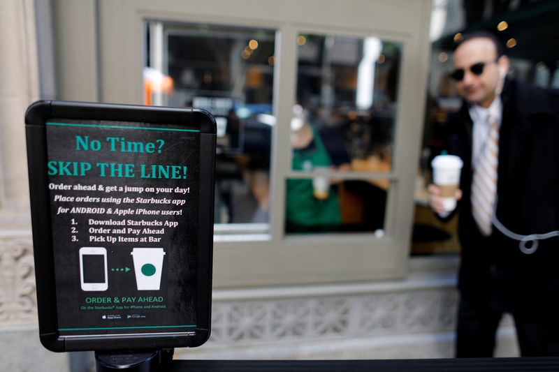 © Reuters. A customer picks-up his smart phone order from a new mobile order window, tested at a Starbucks coffee shop in downtown Los Angeles