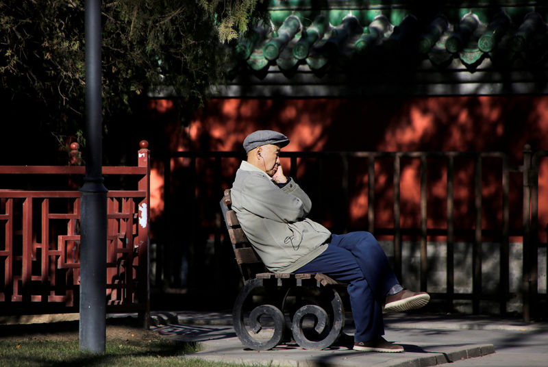 © Reuters. FILE PHOTO: A resident is pictured at a park on a sunny winter day in central Beijing