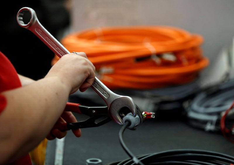 © Reuters. A worker attaches a connector to electrical wire on the factory floor of PP Control and Automation near Cannock