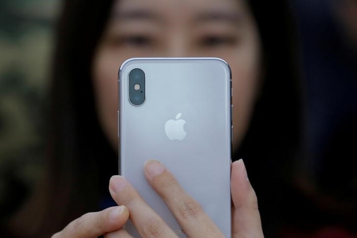 © Reuters. FILE PHOTO - A attendee uses a new iPhone X during a presentation for the media in Beijing