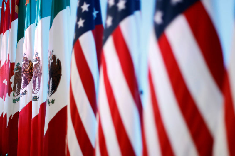 © Reuters. Flags of Canada, Mexico and the U.S. are seen before a joint news conference on the closing of the seventh round of NAFTA talks in Mexico City