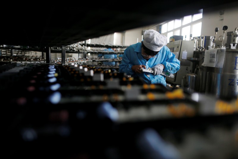 © Reuters. Labourer works inside an electronics factory in Qingdao