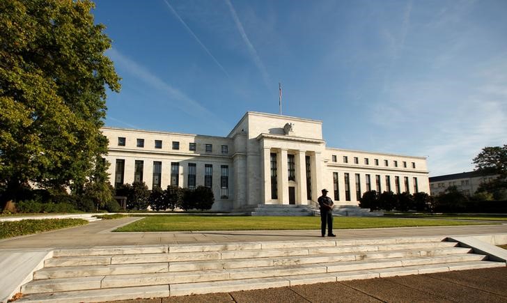 © Reuters. FILE PHOTO - A police officer keeps watch in front of the U.S. Federal Reserve in Washington