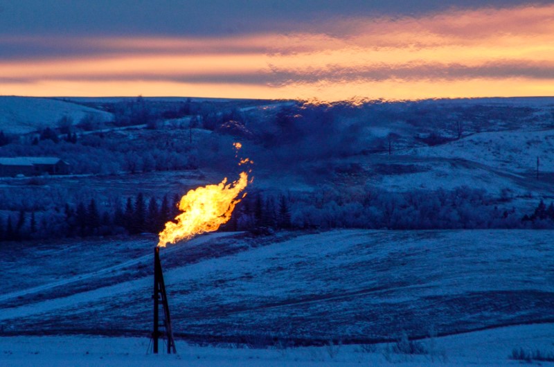 © Reuters. A natural gas flare on an oil well pad burns as the sun sets outside Watford City, North Dakota