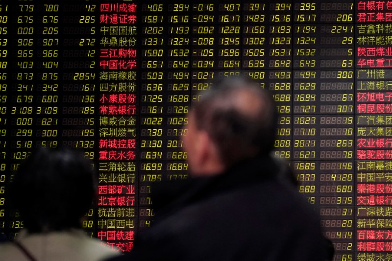 © Reuters. Investidores observam dados de ações em casa de corretagem em Xangai, na China