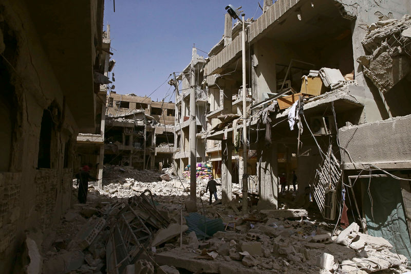 © Reuters. Destroços de prédios bombardeados em Douma