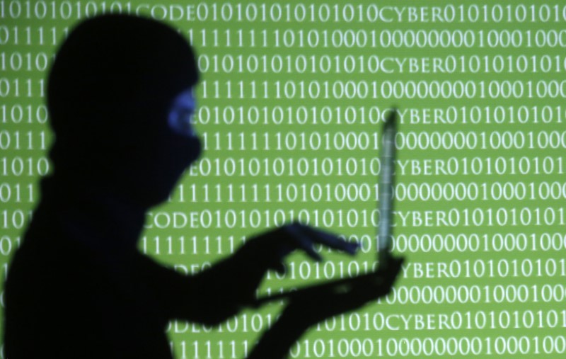 © Reuters. Homem posa segurando laptop em frente a códigos binários, em foto ilustrativa