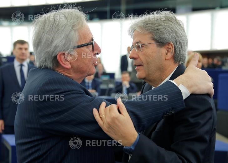 © Reuters. Il presidente della Commissione Ue, Jean Claude Juncker, abbraccia il premier italiano uscente Paolo Gentiloni a Strasburgo