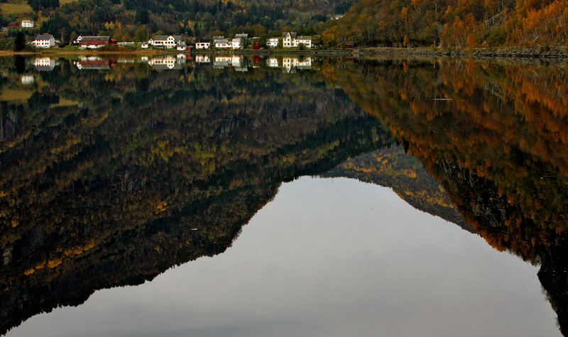 © Reuters. FILE PHOTO: A row of wooden houses are reflected in the still waters of a fjord in western Norway