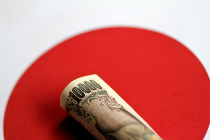 © Reuters. Банкнота 10000 иен на фоне японского флага