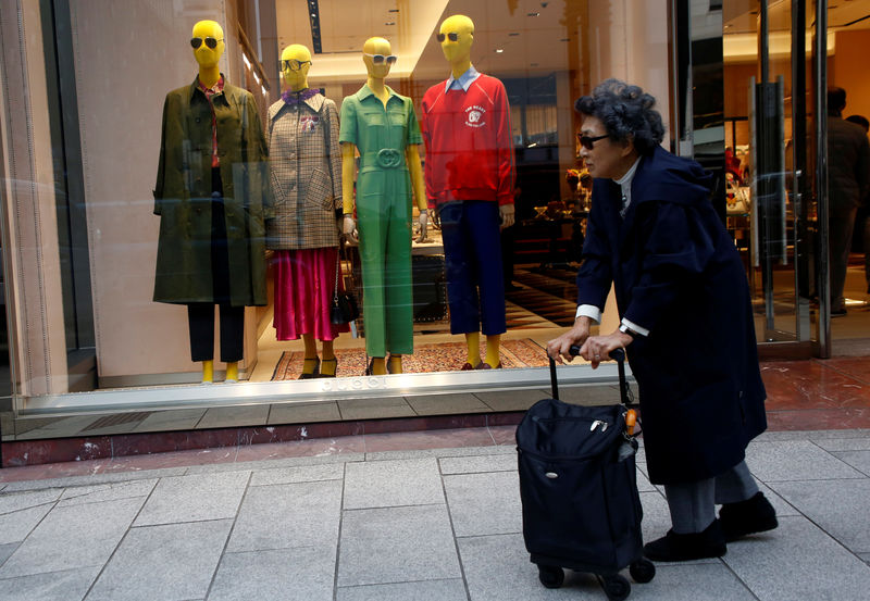 © Reuters. Una donna a passeggio nello shopping district a Tokyo