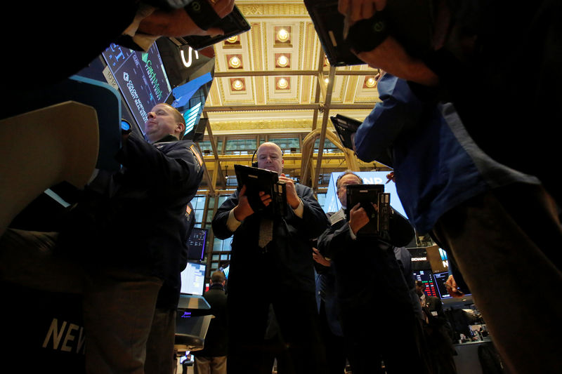 © Reuters. FILE PHOTO: Traders work on the trading floor at the New York Stock Exchange (NYSE) in Manhattan, New York