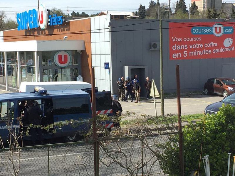 © Reuters. Policiais são vistos ao lado de supermercado onde homem mantinha reféns em Trèbes, na França