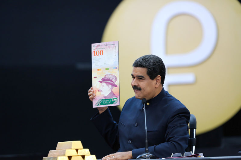 © Reuters. FILE PHOTO: Venezuela's President Nicolas Maduro holds a specimen of the new one hundred-bolivar banknote during a meeting with ministers responsible for the economic sector at Miraflores Palace in Caracas