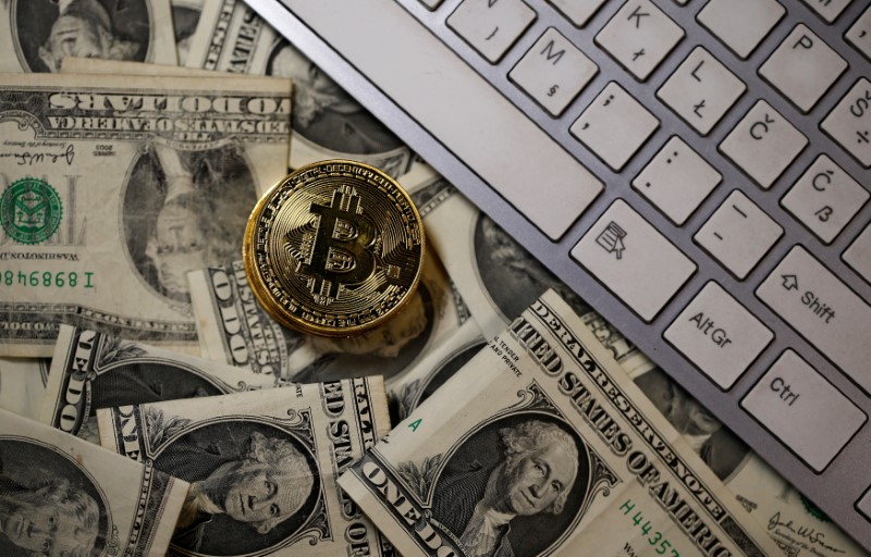 © Reuters. A bitcoin (virtual currency) coin placed on Dollar banknotes is seen in this illustration picture