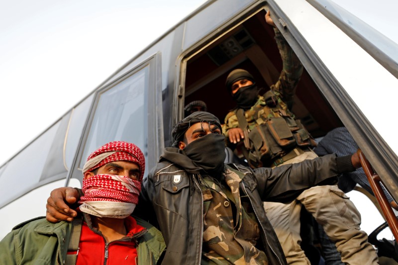 © Reuters. Rebeldes ficam próximos a ônibus antes de retirada da região de Ghouta Oriental