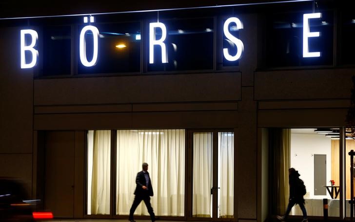 © Reuters. A man walks under the illuminated word "Borse" as he passes the headquarters of Swiss stock exchange operator SIX Group in Zurich