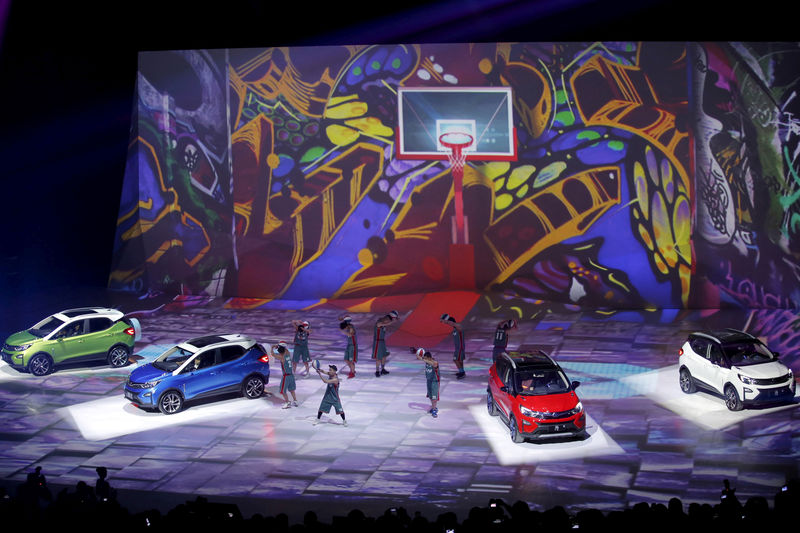 © Reuters. FILE PHOTO: Performers perform next to BYD's hybrid electric cars 'Yuan' on a stage at BYD Dreamcast conference in Beijing