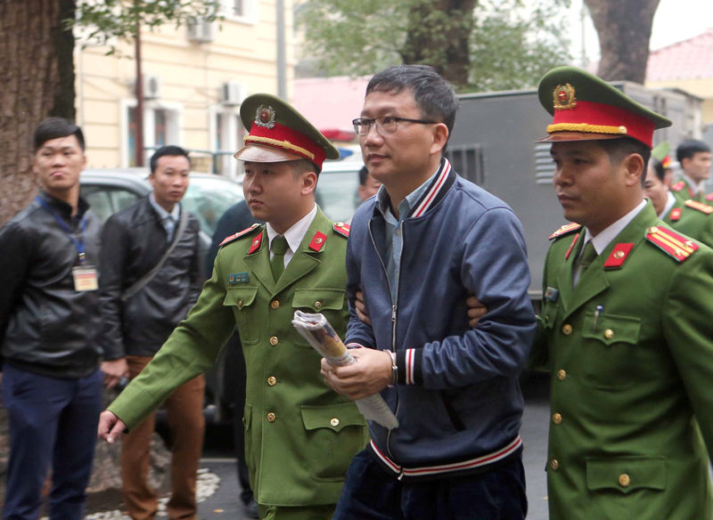 © Reuters. PVC's former chairman Trinh Xuan Thanh is escorted by police to the court in Hanoi