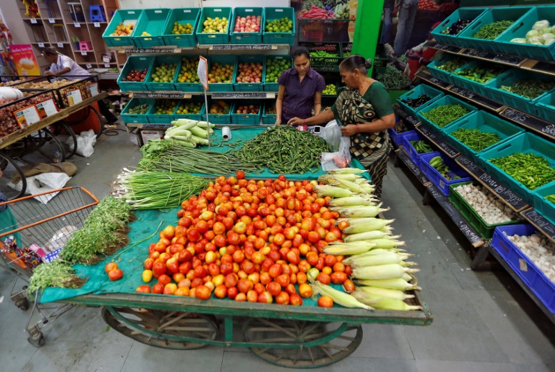 © Reuters. FILE PHOTO: A woman buys vegetables at a food superstore in Ahmedabad