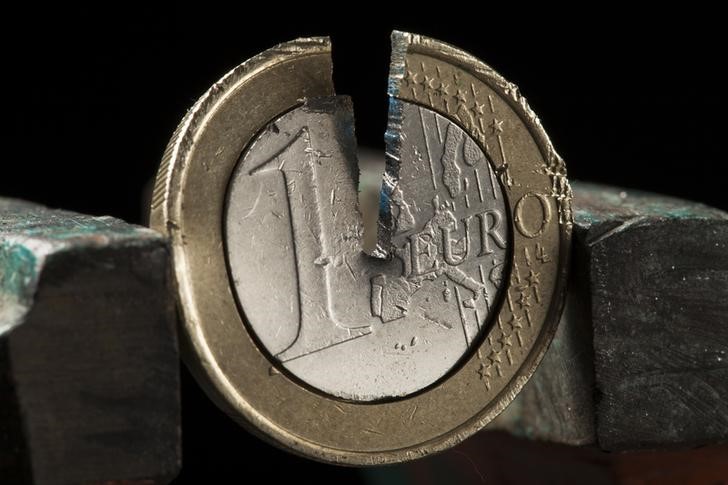 © Reuters. Photo illustration of damaged one Euro coin being held in a vise