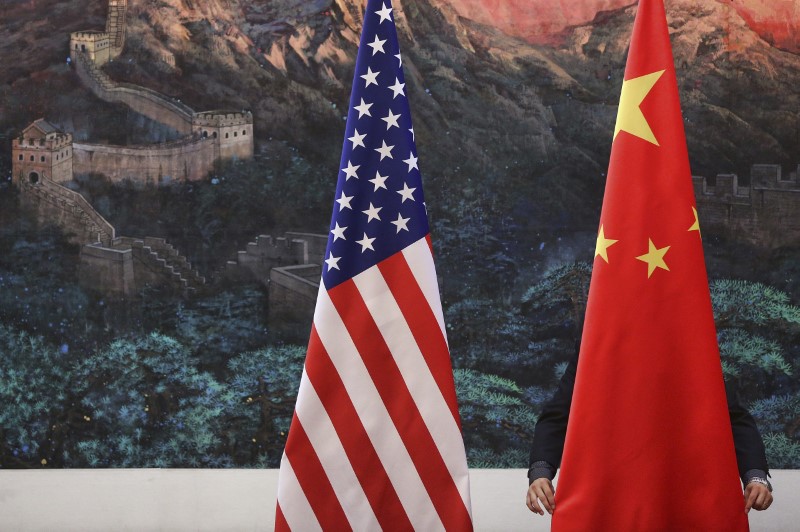 © Reuters. Bandeiras dos Estados Unidos e da China são ajustadas antes de coletiva de imprensa em Pequim