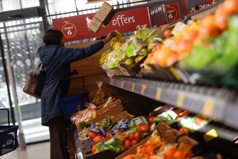 © Reuters. FILE PHOTO - A shopper selects fruit in an Aldi store in London