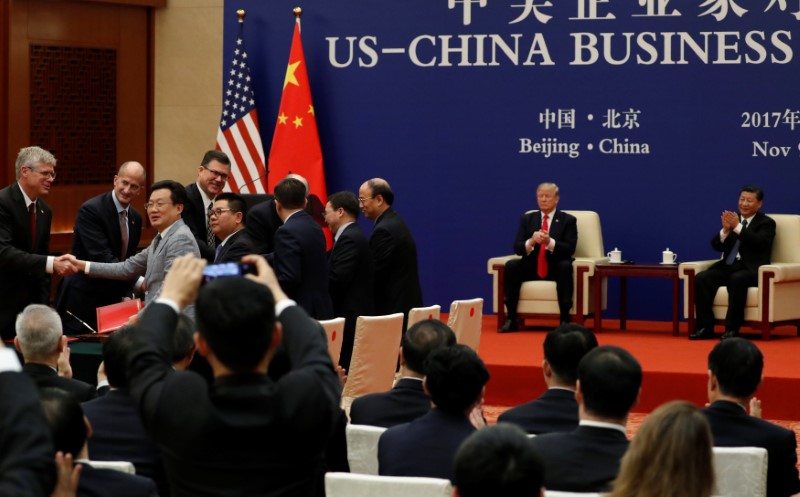 © Reuters. China's President Xi Jinping and U.S. President Donald Trump witness U.S. and Chinese business leaders signing trade deals at the Great Hall of the People in Beijing