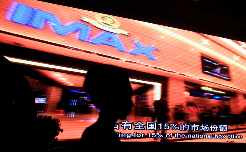© Reuters. FILE PHOTO: A model stands in front of a video presentation before the start of an official signing ceremony between Wanda Group and AMC Entertainment in Beijing