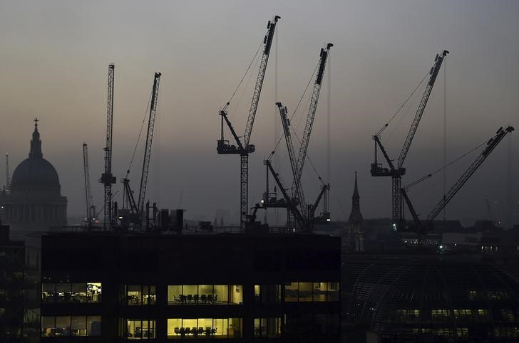 © Reuters. Offices are seen at dusk as St. Paul's cathedral and construction cranes are seen on the skyline in the City of London