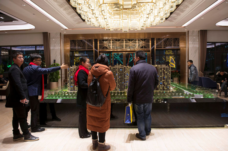 © Reuters. People stand in front of residential building models at a Country Garden property showroom in Huaian