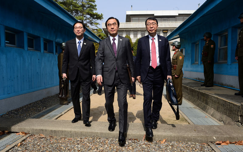 © Reuters. South Korean delegation led by Unification Minister Cho Myoung-gyon cross the concrete border as they leave after their meeting at the truce village of Panmunjom
