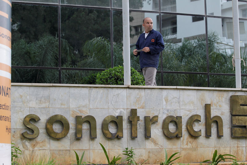 © Reuters. FILE PHOTO: An employee stands near the headquarter  building of the state energy company Sonatrach in Algiers