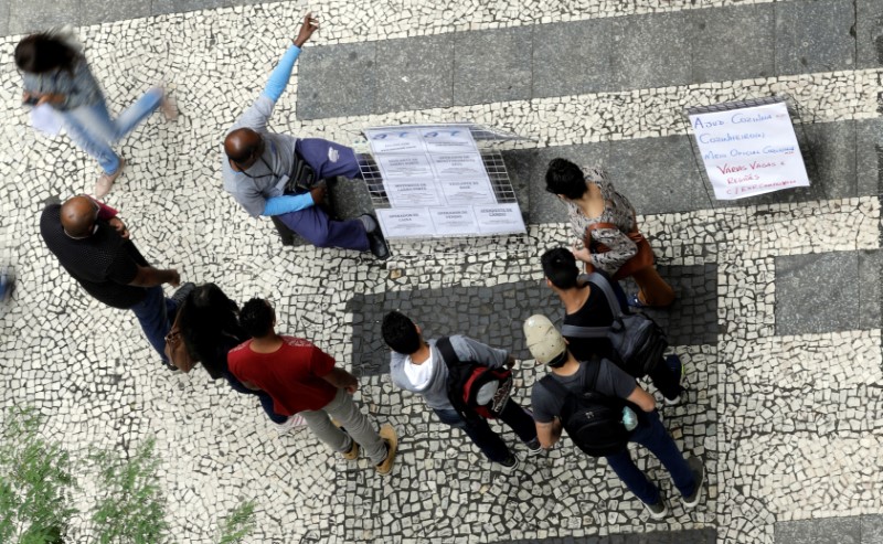 © Reuters. Pessoas observam lista de vagas de trabalho em São Paulo