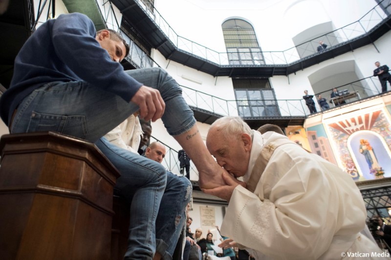 © Reuters. Papa Francisco beija pé na Quinta-Feira Santa