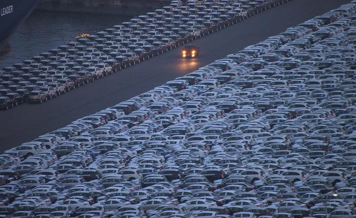 © Reuters. FILE PHOTO - Truck is driven down a road at a yard where cars are parked before being exported at a port in Incheon