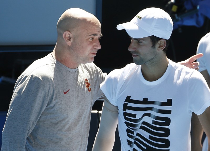 © Reuters. El tenista serbio Novak Djokovic habla con su entrenador Andre Agassi durante una sesión de práctica antes del Abierto de Australia