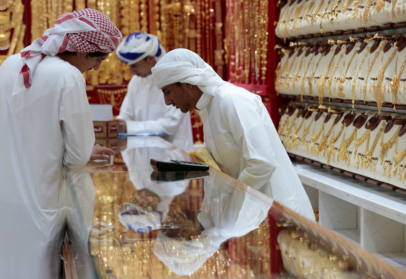 © Reuters. Men look at gold jewellery in a shop at the Gold Souq in Dubai