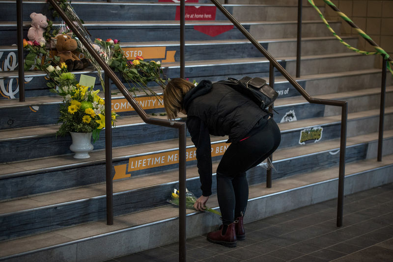 © Reuters. Una residente de Tisdale deja flores en honor a las víctimas del equipo de hockey sobre hielo Humboldt  Broncos en el estadio Edgar Peterson Arena en la provincia de Saskatchewan, Canadá.