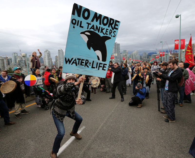 © Reuters. FILE PHOTO: A protester dances with a sign during a march against the proposed expansion of Kinder Morgan's Trans Mountain Pipeline in Vancouver