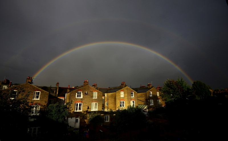© Reuters. FILE IMAGE: A double rainbow is seen above a row of terrace houses in Clapham, south London