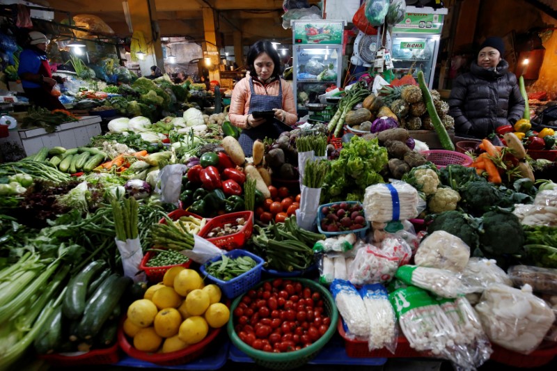© Reuters. Mulher vende vegetais em feira em Hanói, no Vietnã